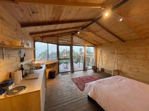a room with a kitchen and a bed in a cabin at La Leopolda in Guatavita