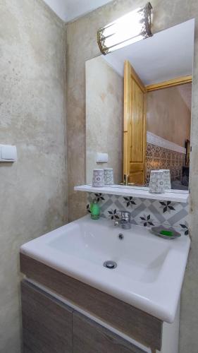 a bathroom with a white sink and a mirror at Riad Inaka in Marrakech
