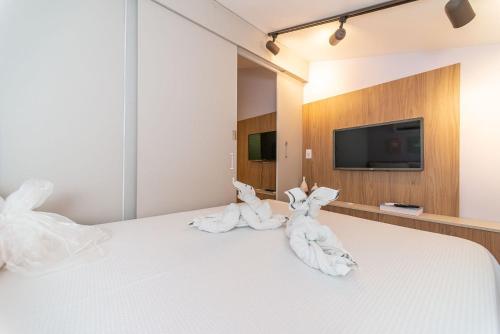 zwei Handtücher in Häschenohren sitzen auf einem Bett in der Unterkunft Nannai Residence Frente Piscina Beira Mar Muro Alto in Porto De Galinhas