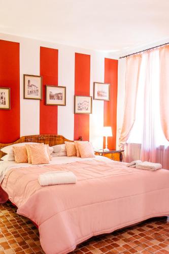 a large bed in a room with red walls at La Fabbrica dell'Oro in Asti