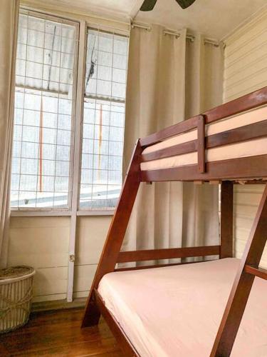 a bunk bed in a room with two windows at Casa Pacífico in Quepos