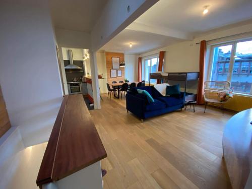 uma sala de estar com um sofá azul e uma mesa em L Etoile de Boulogne proche plage et nausicaa em Boulogne-sur-Mer
