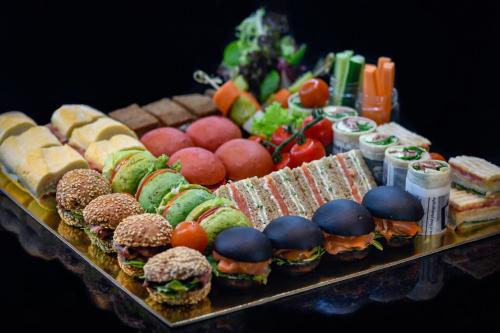 a tray of food with sandwiches and fruit and vegetables at InterContinental Bahrain by IHG in Manama