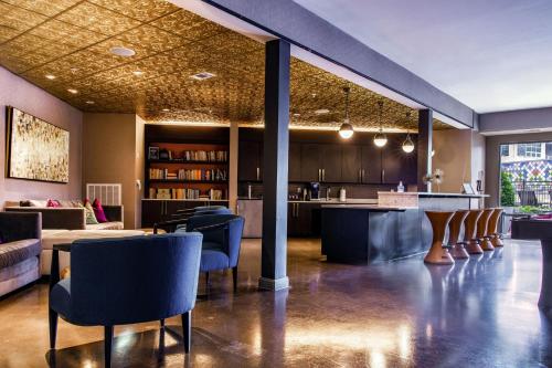 a lobby with chairs and a bar in a building at Placemakr Music Row - Vanderbilt in Nashville