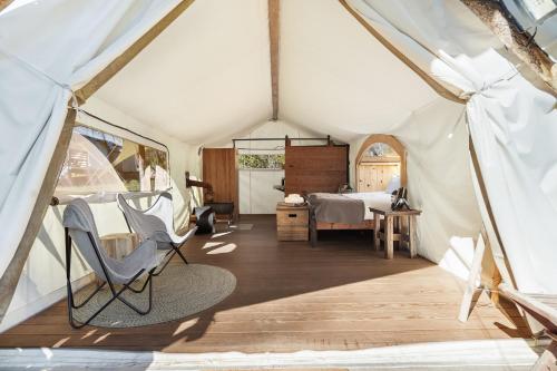 a tent with a bed and a chair in it at Under Canvas Great Smoky Mountains in Pigeon Forge