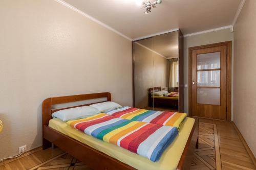 a bedroom with a bed with a colorful striped blanket at Apartment Kiev House in Kyiv