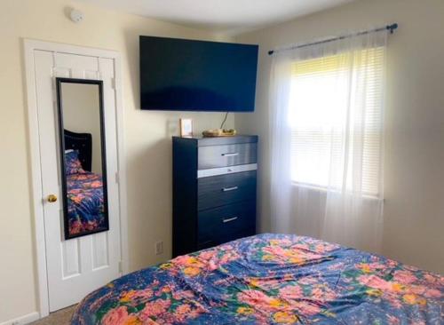 een slaapkamer met een bed en een flatscreen-tv bij Cozy Two Bedroom Apartment in the City Center in Trenton