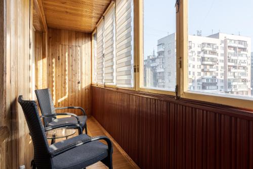 two chairs sitting on a balcony with a window at Apartment Kiev House in Kyiv