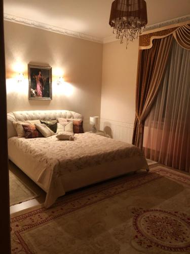 a bedroom with a bed and a chandelier at УЮТНЫЙ ДОМ ДЛЯ ОТДЫХА, город-Бендеры ,Приднестровье in Bender