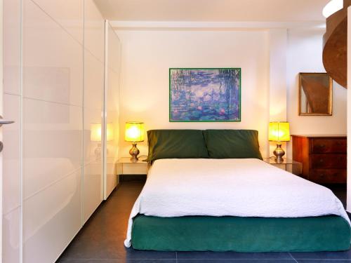 Un dormitorio con una cama grande con dos lámparas. en Depadance Limoni, en Gardone Riviera