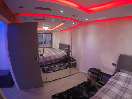 una camera con due letti e luci rosse sul soffitto di Perfect Central London Base a Londra