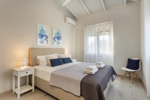 um quarto branco com uma cama grande e uma cadeira em Marika's Penthouse Chania em Chania Town