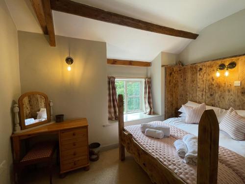 een slaapkamer met een bed, een spiegel en een dressoir bij Pond Cottage in Rosedale Abbey