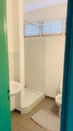 een badkamer met een bad, een toilet en een wastafel bij ST-Laurent Centre Confort T2 in Saint-Laurent du Maroni