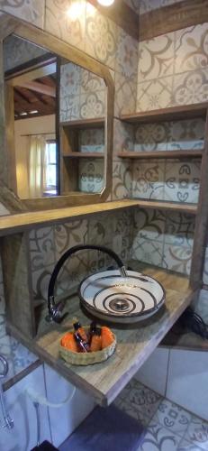 Un mostrador con un plato de comida y un espejo. en Pousada da Oma, en Cunha