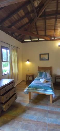 Un dormitorio con una cama y una cómoda. en Pousada da Oma, en Cunha