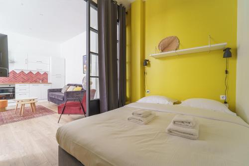 une chambre avec un grand lit avec des serviettes dessus dans l'établissement Parisuites Central Canal Saint Martin Chic & Design & Cosy, à Paris