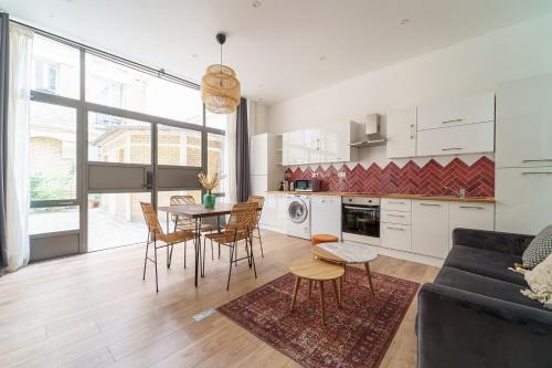 une cuisine et un salon avec une table et des chaises dans l'établissement Parisuites Central Canal Saint Martin Chic & Design & Cosy, à Paris