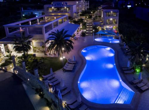 a pool at a resort at night at Isida Hotel Agia Marina in Agia Marina Nea Kydonias