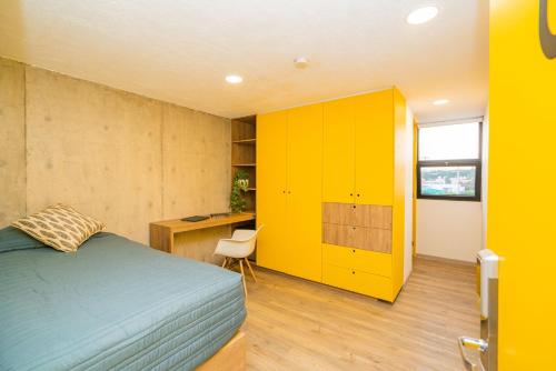 um quarto com uma cama, uma secretária e um armário amarelo em MS Loft Coworking Vigilancia 24hrs Internet Amenities 410 em Laborcillas