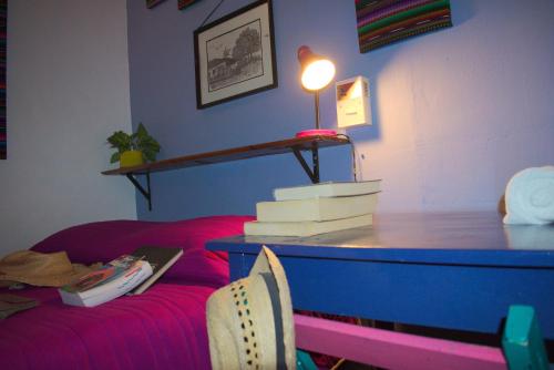 sala de estar con mesa y sofá rojo en Hostel Candelaria, en Valladolid