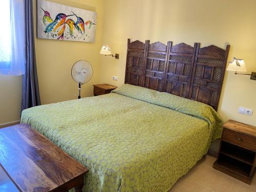 a bedroom with a bed with a green bedspread at Cosy apartment in Corralejo, shared pool, 55 m² in Corralejo