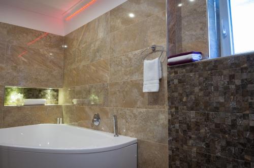 a bathroom with a tub and a toilet and a window at Villa Kiwi in Mikulov