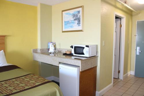 a hotel room with a microwave and a bed at Ocean Resort in Virginia Beach