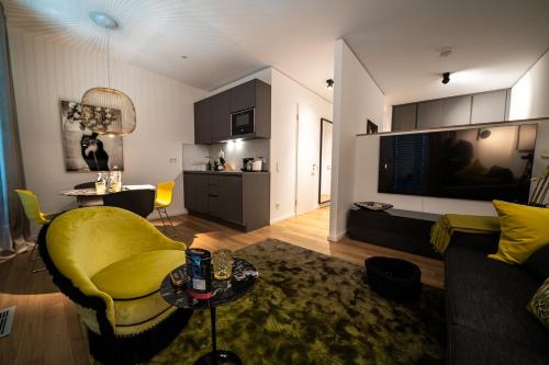 a living room with a yellow chair and a couch at Luxury Apartments Düsseldorf in Düsseldorf