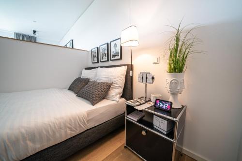 デュッセルドルフにあるLuxury Apartments Düsseldorfのベッドルーム1室(ベッド1台、テーブル、電話付)