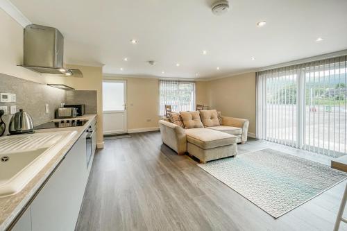 een keuken en een woonkamer met een bank en een tafel bij Barra Cottage in Ballachulish