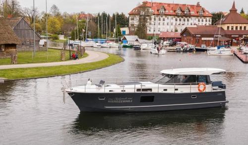 a boat is docked in a body of water at Jacht motorowy Nautika 1300 LUX in Wilkasy