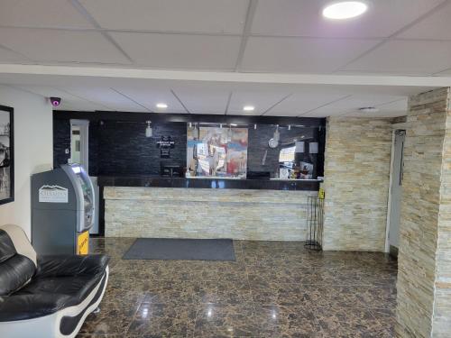 a lobby with a bar and a couch in a room at Super 8 North Red Deer in Red Deer