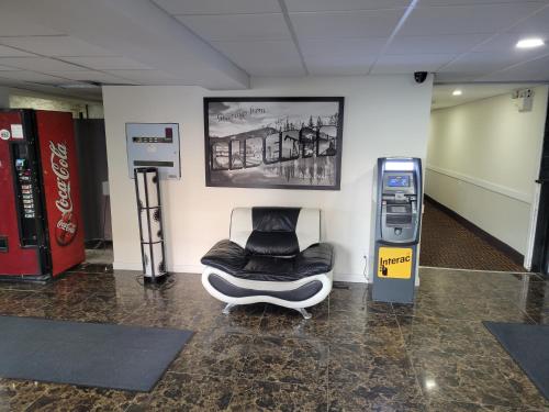 a waiting room with a chair next to a machine at Super 8 North Red Deer in Red Deer