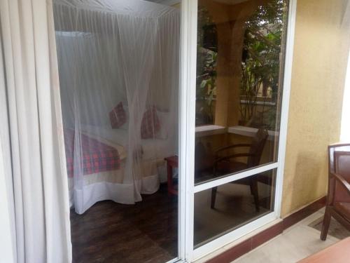 a room with a sliding glass door leading to a bedroom at Karibu Heritage House in Arusha