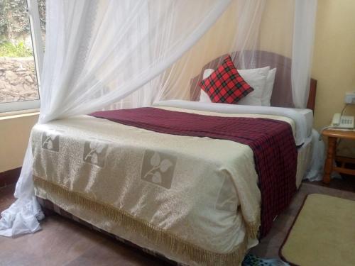 a bedroom with a bed with a canopy at Karibu Heritage House in Arusha