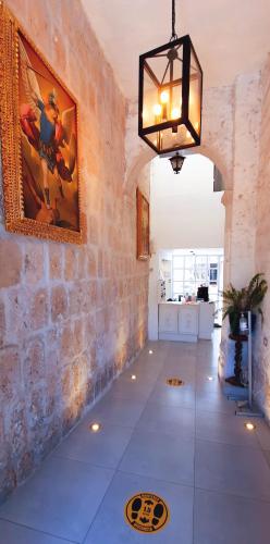 a room with a stone wall and a chandelier at Chikan Hoteles in Arequipa