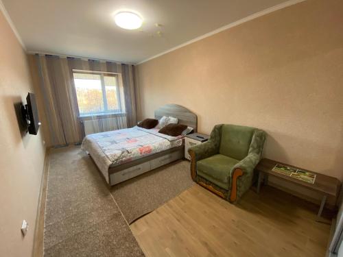 - une petite chambre avec un lit et une chaise dans l'établissement ЖК Резиденція Кориатовичів 114 корпус 5, à Vinnytsia