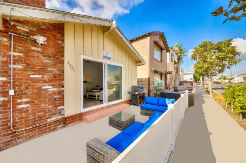 a patio with blue chairs and a brick building at Balboa Duplex in Newport Beach