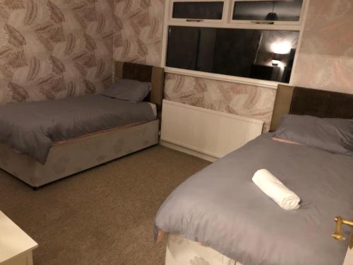 a room with two beds and a window at Number One - Fully Equipped Self Catering Four Bedroom House next to Dunedin, 15 mins to Spurn, 20 mins to Saltend, 12 mins to Easington in Patrington