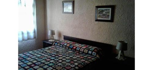 a bedroom with a bed with a quilt on it at Posada 5a. Reverie in Cuchilla Alta