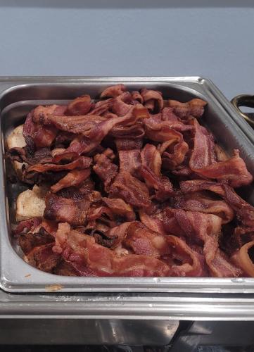 a pan full of bacon in a pan at Vero Beach Inn & Suites Vero Beach I-95 in Vero Beach