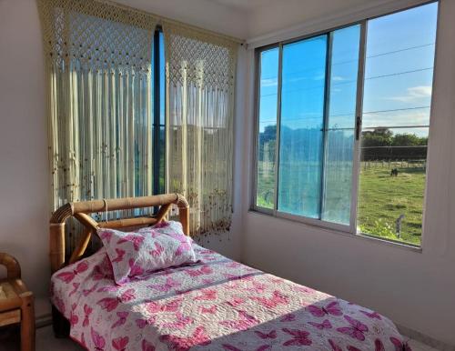 a bedroom with a bed and a window with a view at PRECIOSA CASA con Piscina, Jacuzzi y BBQ en Girardot in Girardot
