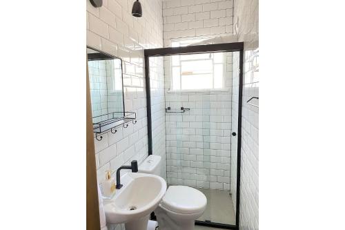 a bathroom with a toilet and a sink at Apto temático Pintura e Porcelana Centro Pomerode in Pomerode