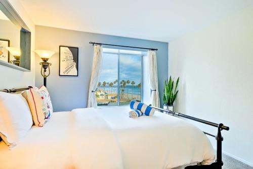 une chambre avec un lit avec vue sur l'océan dans l'établissement Pier View Retreat - Beachfront beauty with ocean views, private balconies, pool/hot tub, & WiFi, à Oceanside