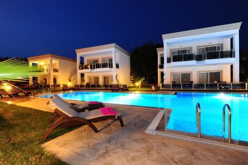 a villa with a swimming pool at night at Delita Suite Hotel Turkbuku in Golturkbuku