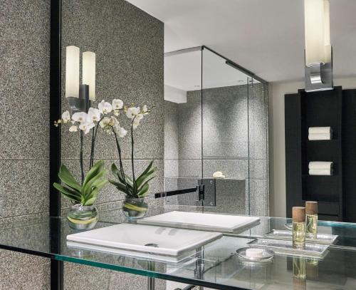 a bathroom with a glass counter with a sink and a mirror at Four Seasons Hotel Bogota in Bogotá