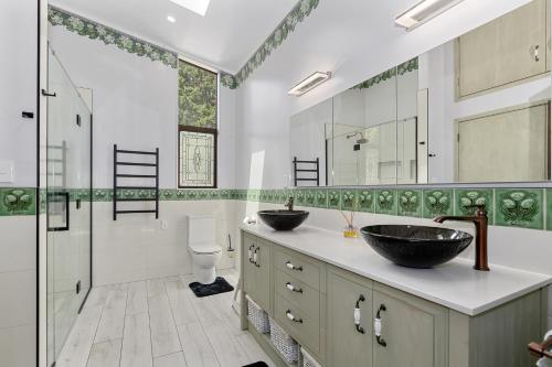 uma casa de banho com 2 lavatórios e um chuveiro em Westhay Stables - Paparoa Holiday Home em Paparoa
