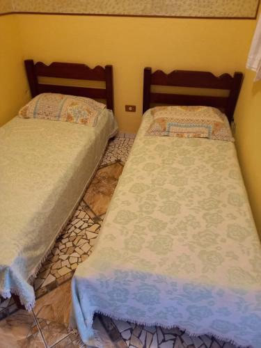 two beds sitting next to each other in a room at Pousada Sitieto Voitov in Aluminio