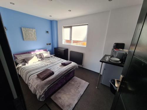 um quarto com uma cama grande e uma parede azul em Oxclose studios em Peterborough